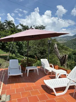 a group of chairs and an umbrella on a patio at Villa en Salgar - Bolombolo in Montenegro