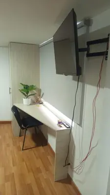 a room with a desk with a chair and a monitor at Apartaestudio muy central entre zonas rosas in Manizales