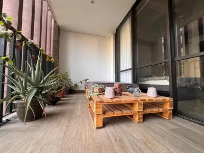 a living room with a wooden bench and plants at Art, design and urban life in Medellín loft in Medellín