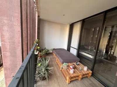 a balcony with a ottoman sitting on top of a building at Art, design and urban life in Medellín loft in Medellín