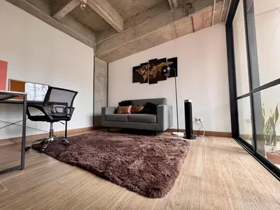 a living room with a couch and a chair at Art, design and urban life in Medellín loft in Medellín