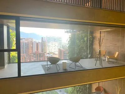 a large window with chairs and tables on a balcony at Art, design and urban life in Medellín loft in Medellín
