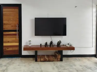 a flat screen tv on a wall with a table at Buenos Aires in Doradal