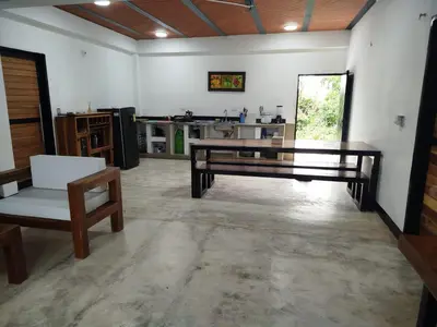 a large living room with a table and a kitchen at Buenos Aires in Doradal