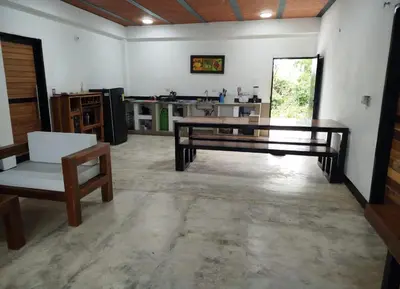 a living room with a bench and a table and a kitchen at Buenos Aires in Doradal