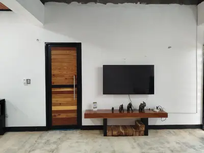a room with a television on a wall with a table at Buenos Aires in Doradal