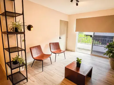 a living room with two chairs and a table at Vive Medellin apartamento in Envigado