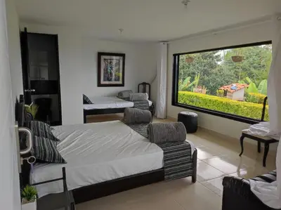 a bedroom with two beds and a large window at Finca Villa Lake in Horizonte