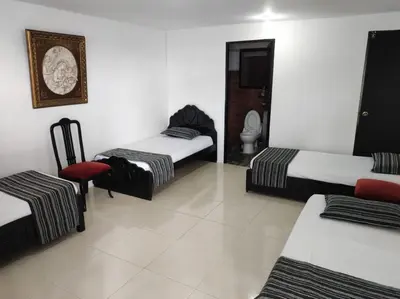 a room with three beds and a toilet in it at Finca Villa Lake in Horizonte