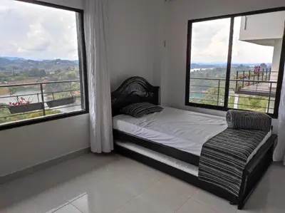 a bedroom with a bed and two large windows at Finca Villa Lake in Horizonte
