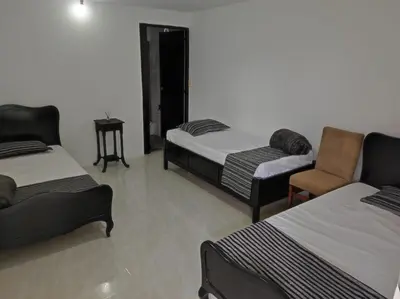 a room with two beds and a chair in it at Finca Villa Lake in Horizonte
