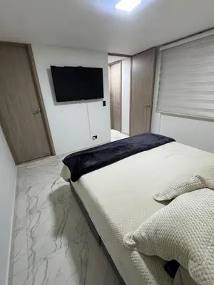 a bedroom with a large bed and a flat screen tv at Apartment in Itagui, excellent location in Itagüí
