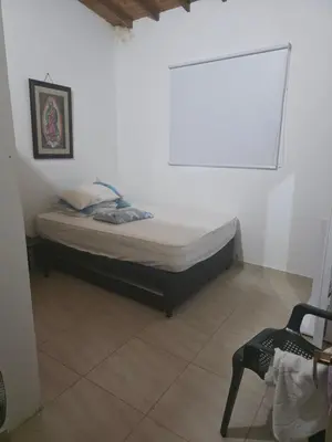 a small bedroom with a bed and a chair at FINCA DE RECREO y DESCANSO in El Bosque