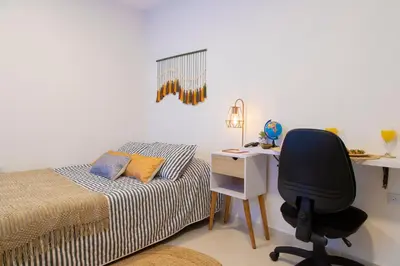 a bedroom with a desk and a bed and a chair at Sencia Apartamentos Boutique in Medellín