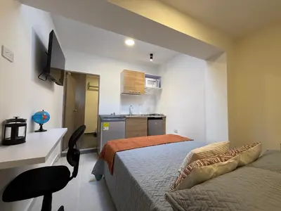 a small bedroom with a bed and a desk and a chair at Sencia Apartamentos Boutique in Medellín