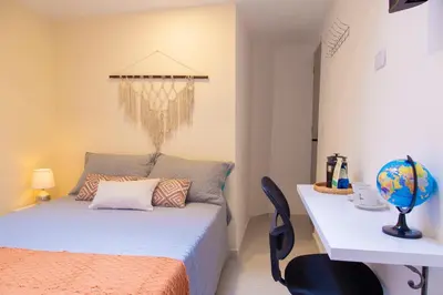 a bedroom with a bed and a table with a desk at Sencia Apartamentos Boutique in Medellín