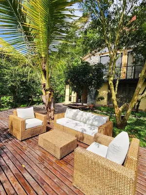 a wooden deck with wicker furniture on a patio at Eco-paradise in coffee heartland in Marulanda