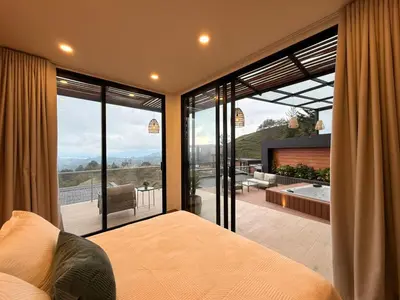 a bedroom with a bed and a large glass window at Montecielo Lodge 11 El peñol - Guatape in Chiquinquirá