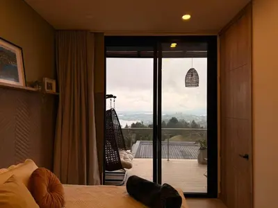 a bedroom with a sliding glass door to a balcony at Montecielo Lodge 11 El peñol - Guatape in Chiquinquirá
