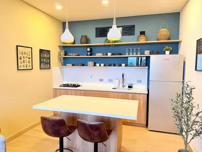 a kitchen with a table and a refrigerator at Montecielo Lodge 11 El peñol - Guatape in Chiquinquirá