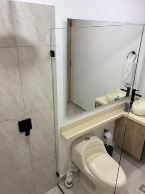 a bathroom with a toilet and a glass shower at Industrial Loft near Poblado, Medellín in Medellín