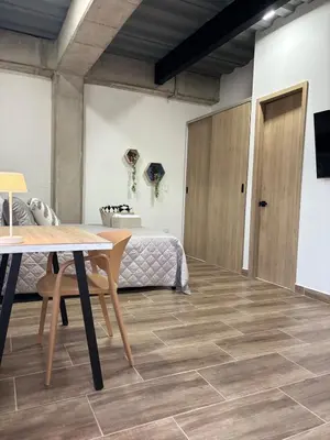 a room with a bed and a table and a table at Industrial Loft near Poblado, Medellín in Medellín