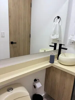 a bathroom with a sink and a toilet and a mirror at Industrial Loft near Poblado, Medellín in Medellín