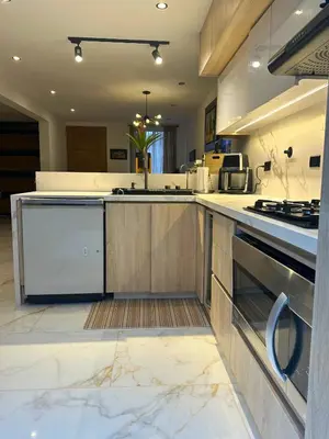 a large kitchen with wooden cabinets and a stove at Casa Bosques La Ceja in La Ceja