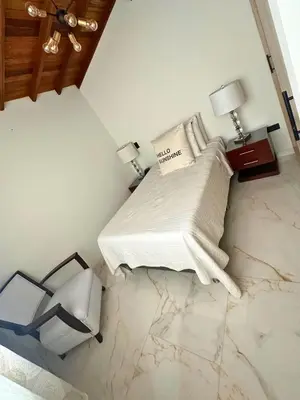 a bedroom with a bed and a table with two lamps at Casa Bosques La Ceja in La Ceja