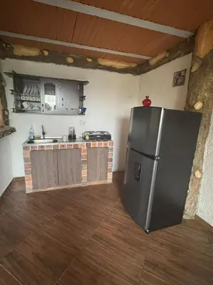 a kitchen with a stainless steel refrigerator in a room at Entre pinos in Chiquinquirá