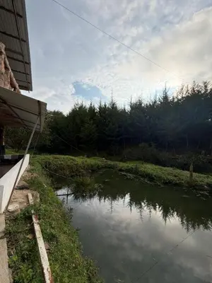 a body of water next to a building with a river at Entre pinos in Chiquinquirá