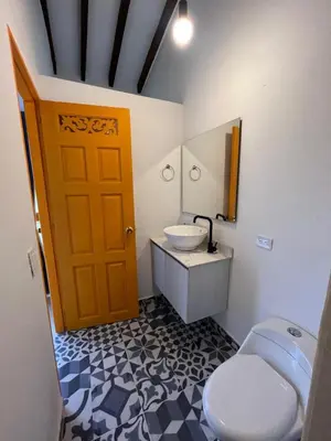 a bathroom with a toilet and a sink and a door at Jerico Poets Balcony House in Jericó
