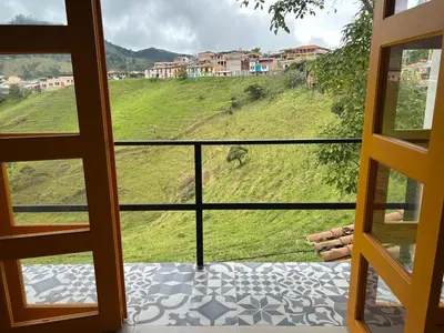 a room with a view of a green hill at Jerico Poets Balcony House in Jericó
