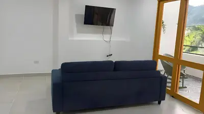 a blue couch in a living room with a television at Jerico Poets Balcony House in Jericó