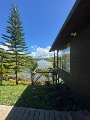a house with a view of a tree and a lake at Cabañas con vista al Embalse in La Pradera
