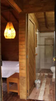 a room with a bed and a bathroom with a chandelier at Cabañas con vista al Embalse in La Pradera