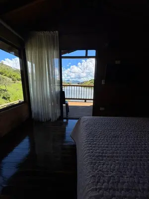 a bedroom with a bed and a window with a view at Cabañas con vista al Embalse in La Pradera