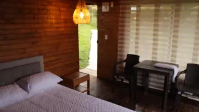 a bedroom with a bed and a desk and a chair at Cabañas con vista al Embalse in La Pradera