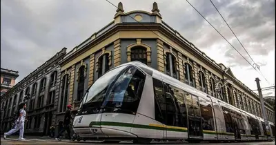 a train on a street in front of a building at Urban Loft in the center in Medellín