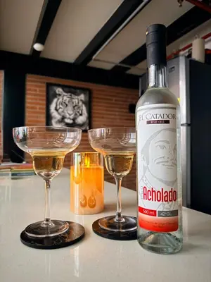 a bottle of alcohol next to two glasses on a counter at Urban Loft in the center in Medellín