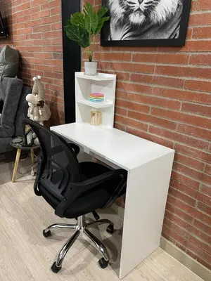 a white desk with a black chair next to a brick wall at Urban Loft in the center in Medellín