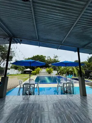 a patio with chairs and umbrellas next to a pool at Vía las palmas in Victoria