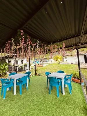 two tables and chairs under a canopy with pink flowers at Vía las palmas in Victoria