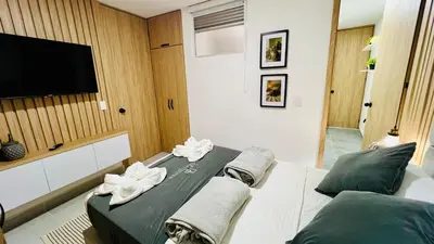 a bedroom with two beds and a flat screen tv at Apto full Ubicación Plazoleta Zocalos Plaza Ppal in Guatapé