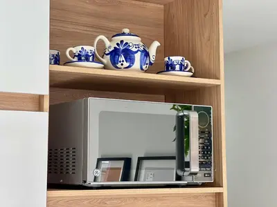 a microwave in a kitchen with blue and white dishes at Apto full Ubicación Plazoleta Zocalos Plaza Ppal in Guatapé