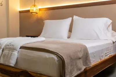 a bedroom with a bed with white sheets and pillows at The Living Hub in La Dorada