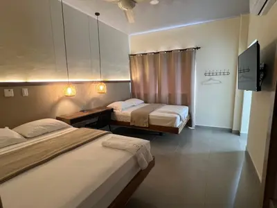 a hotel room with two beds and a tv at The Living Hub in La Dorada
