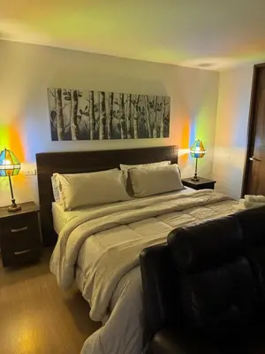 a bedroom with a large bed with two lamps at Reposso Laureles in Medellín