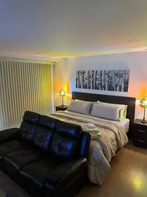 a bedroom with a large bed and a leather couch at Reposso Laureles in Medellín