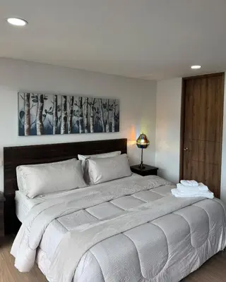 a large white bed in a bedroom with at Reposso Laureles in Medellín